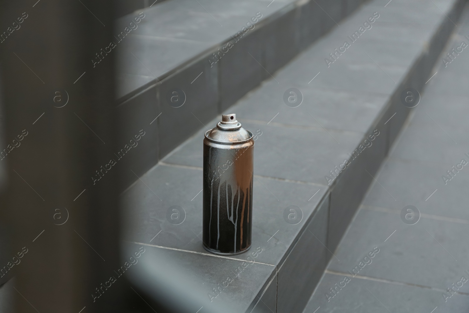 Photo of Used can of spray paint on stairs. Space for text