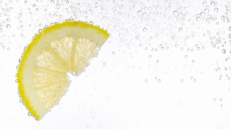 Refreshing soda water and lemon slice against white background. Banner design