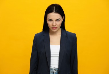 Photo of Angry young woman on yellow background. Hate concept