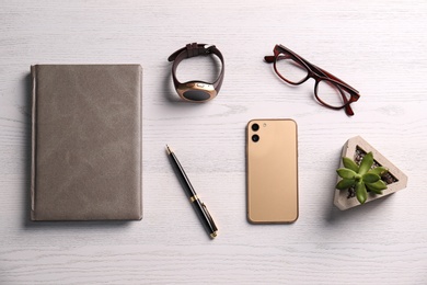 Photo of Flat lay composition with stylish smart watch on white wooden table