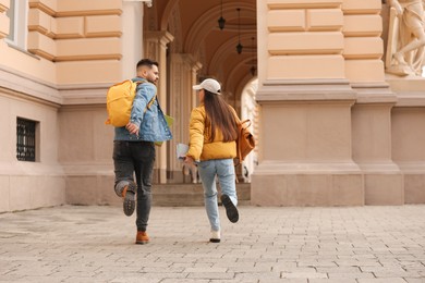 Photo of Being late. Students running towards building outdoors, space for text