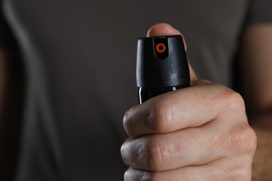 Man using pepper spray, closeup. Space for text