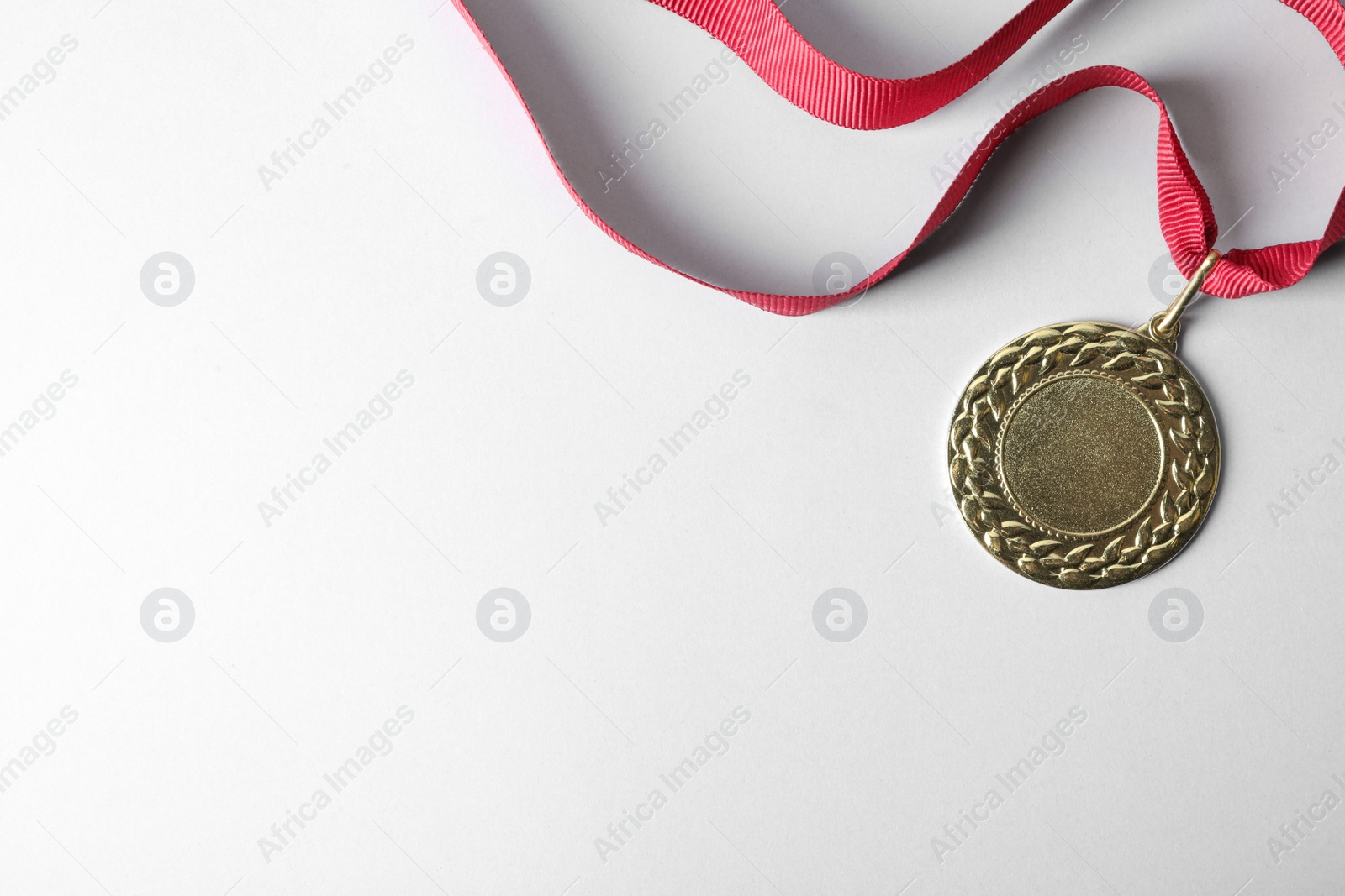 Photo of Gold medal with space for design on light background, top view. Victory concept