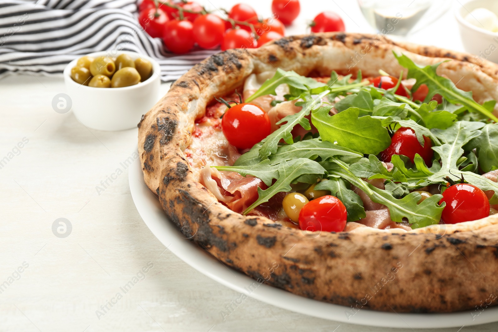 Photo of Tasty pizza with meat and arugula on white table, closeup