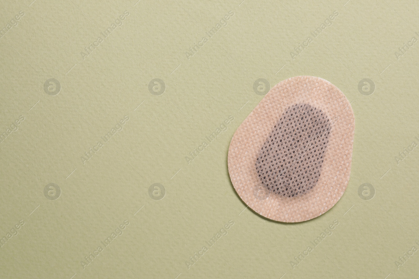 Photo of Contraceptive patch on green background, top view. Space for text