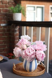 Beautiful pink peony flowers in vase at balcony