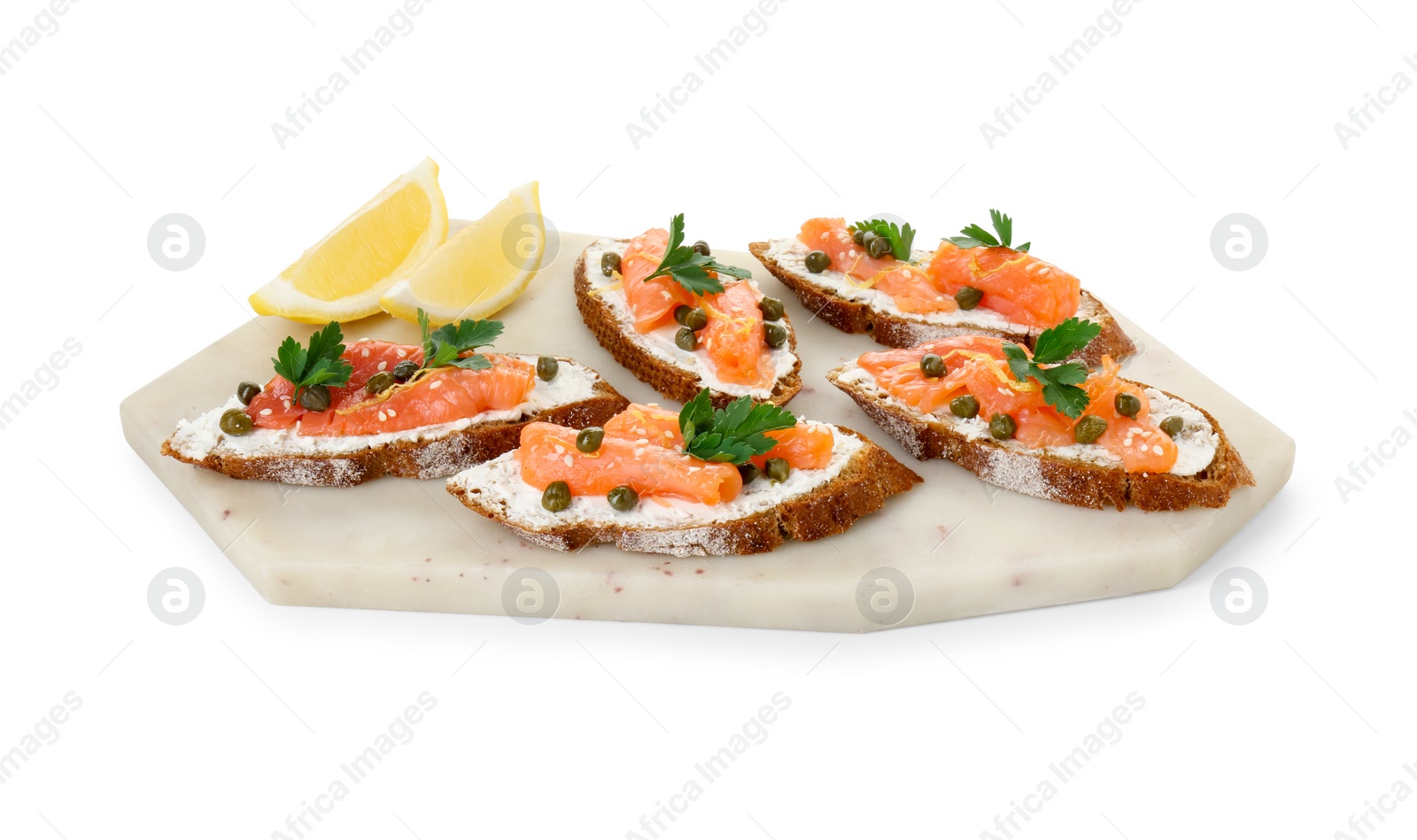 Photo of Tasty canapes with salmon, capers, lemon and cream cheese isolated on white