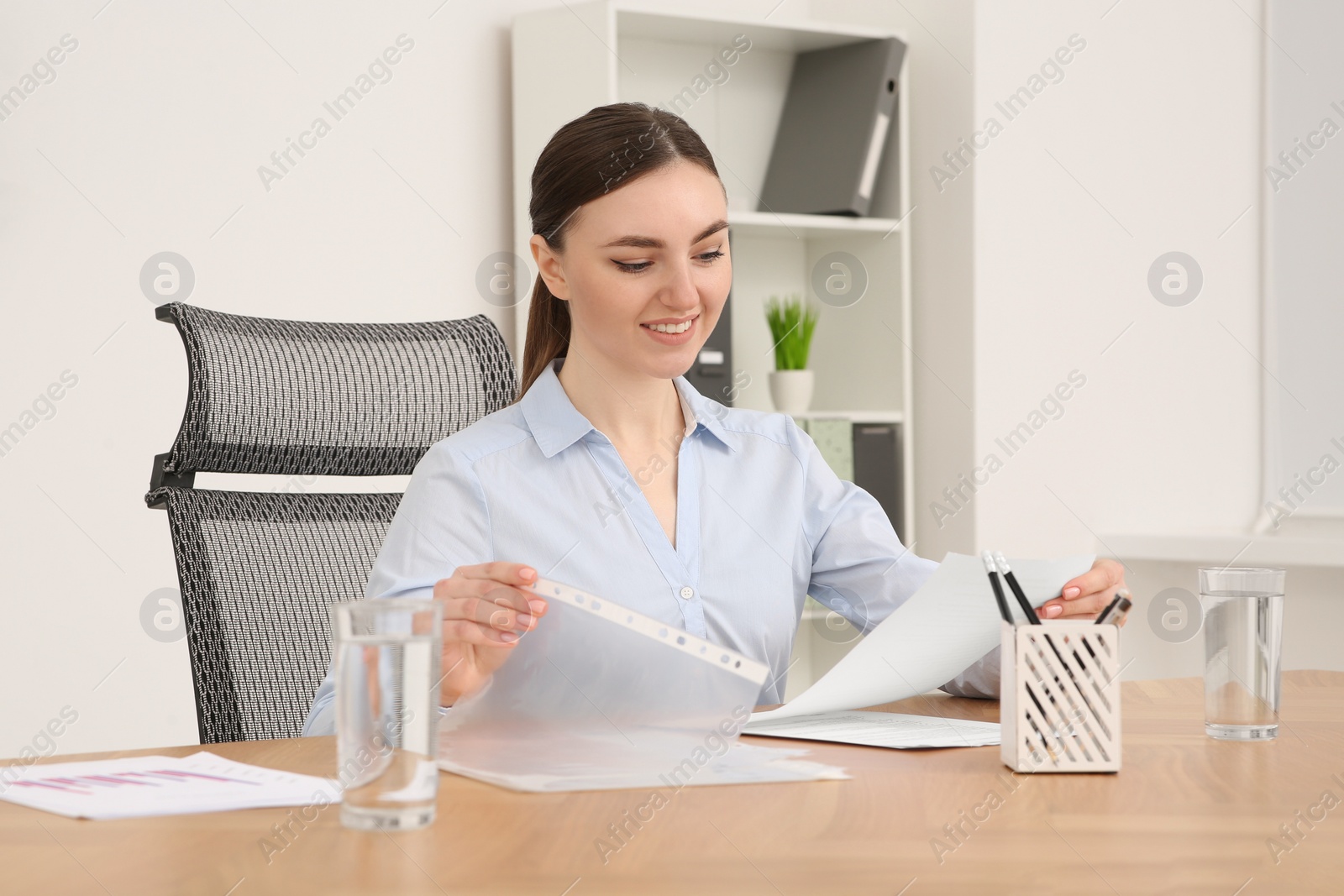 Photo of Businesswoman working with documents at wooden table in office