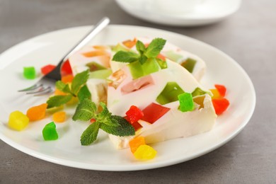 Photo of Delicious broken glass jelly dessert on grey table, closeup