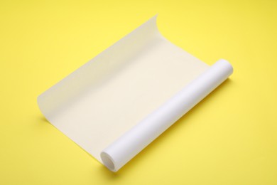 Roll of baking paper on yellow background
