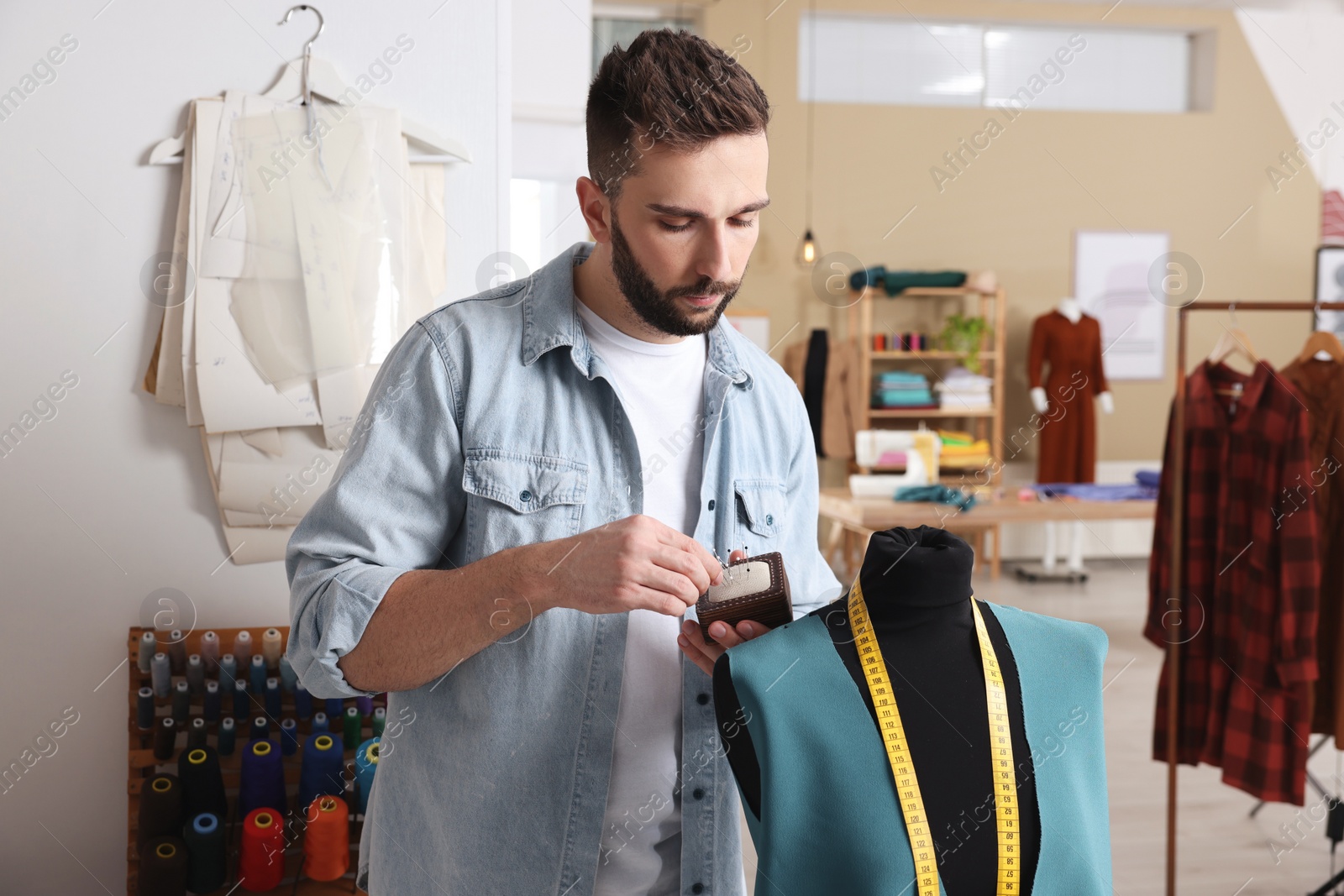 Photo of Dressmaker working with mannequin in modern atelier