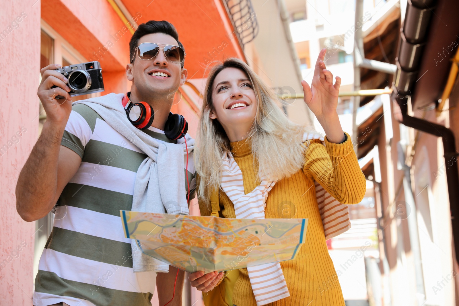 Photo of Couple of tourists with map and camera on city street