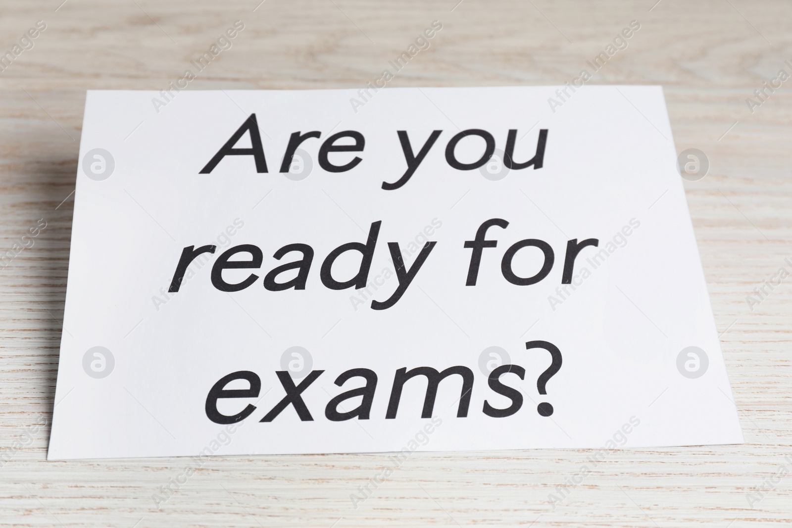 Photo of Paper with question Are you ready for exams on white wooden table, closeup