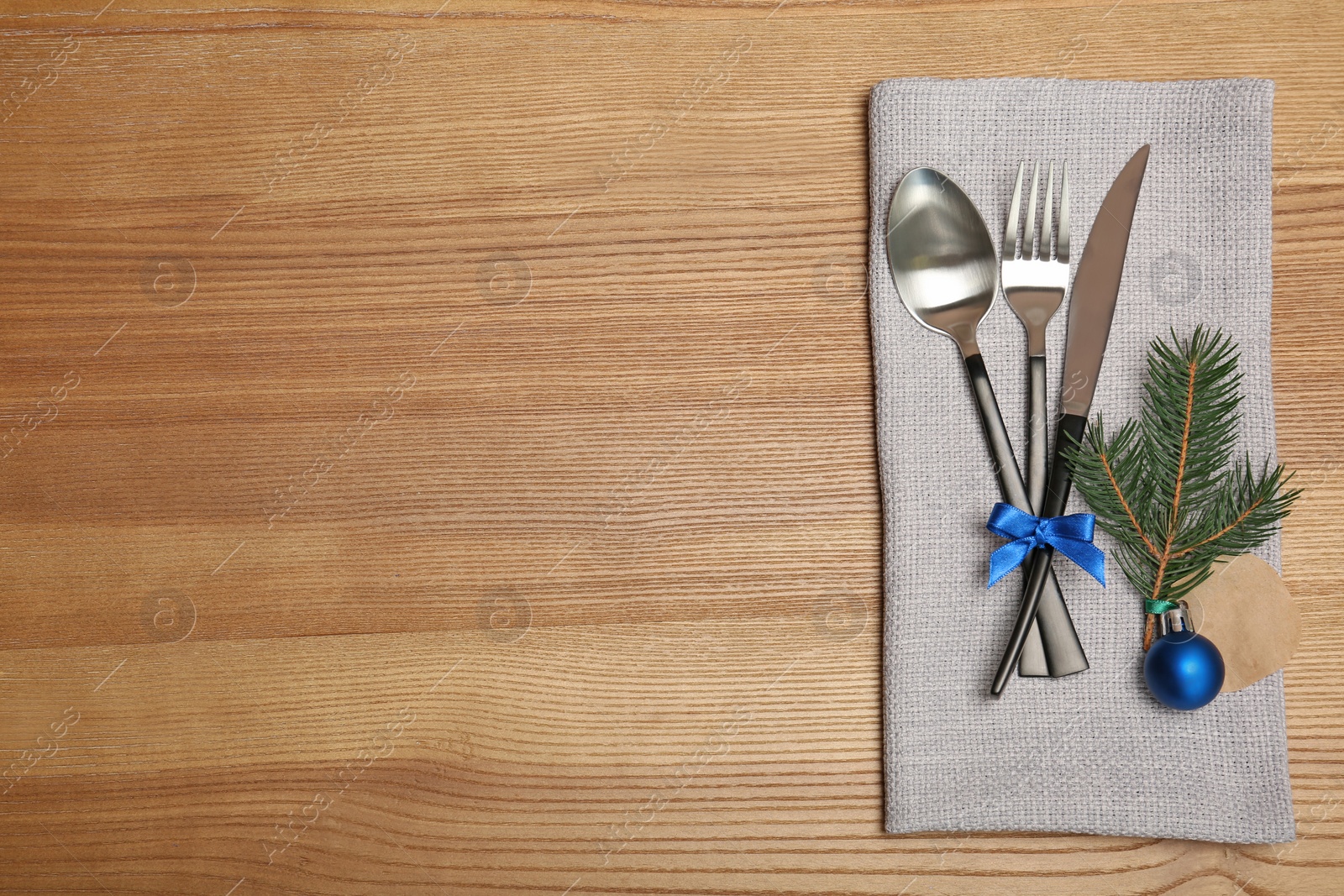 Photo of Cutlery and napkin on wooden background, top view. Table setting