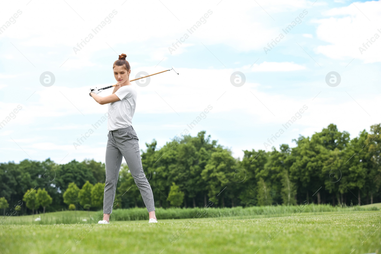 Photo of Woman playing golf on green course. Sport and leisure