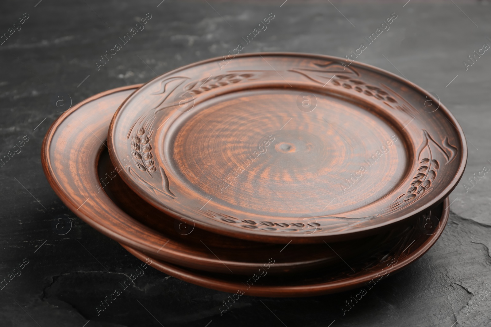 Photo of Stack of clay plates on black table