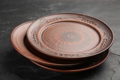 Photo of Stack of clay plates on black table