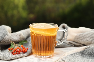 Cup of hot drink and scarf on window sill indoors. Cozy autumn atmosphere