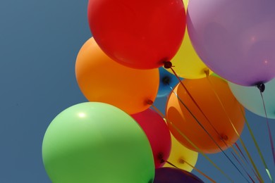 Photo of Bunch of colorful balloons against blue sky, closeup