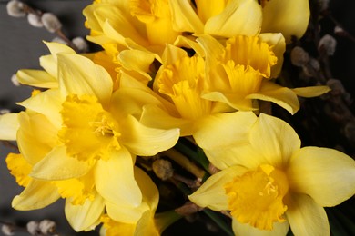 Photo of Beautiful yellow daffodils and willow twigs on grey background, top view
