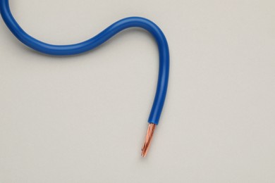 Photo of Blue electrical wire on light background, top view
