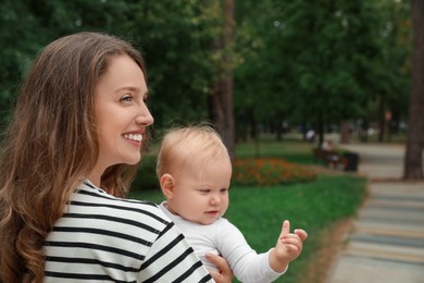 Photo of Mother with her cute baby spending time together outdoors. Space for text