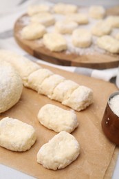 Photo of Making lazy dumplings. Raw dough and flour on table, closeup