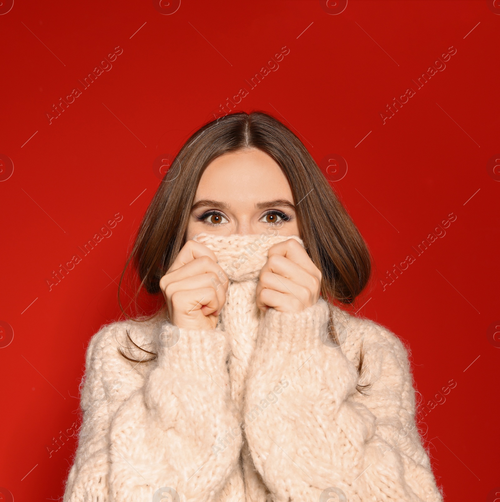 Photo of Young woman wearing Christmas sweater on red background