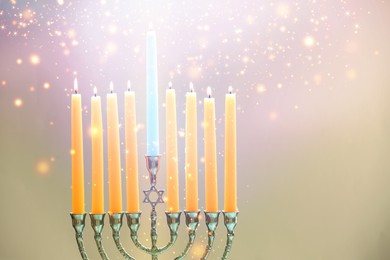 Hanukkah celebration. Menorah with burning candles on beige background, closeup. Space for text