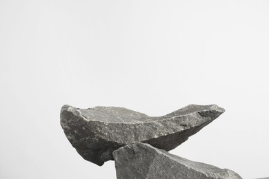 Photo of Presentation for product. Podium made of stones on light grey background. Space for text