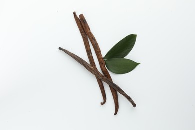 Photo of Aromatic vanilla pods and leaves isolated on white, top view