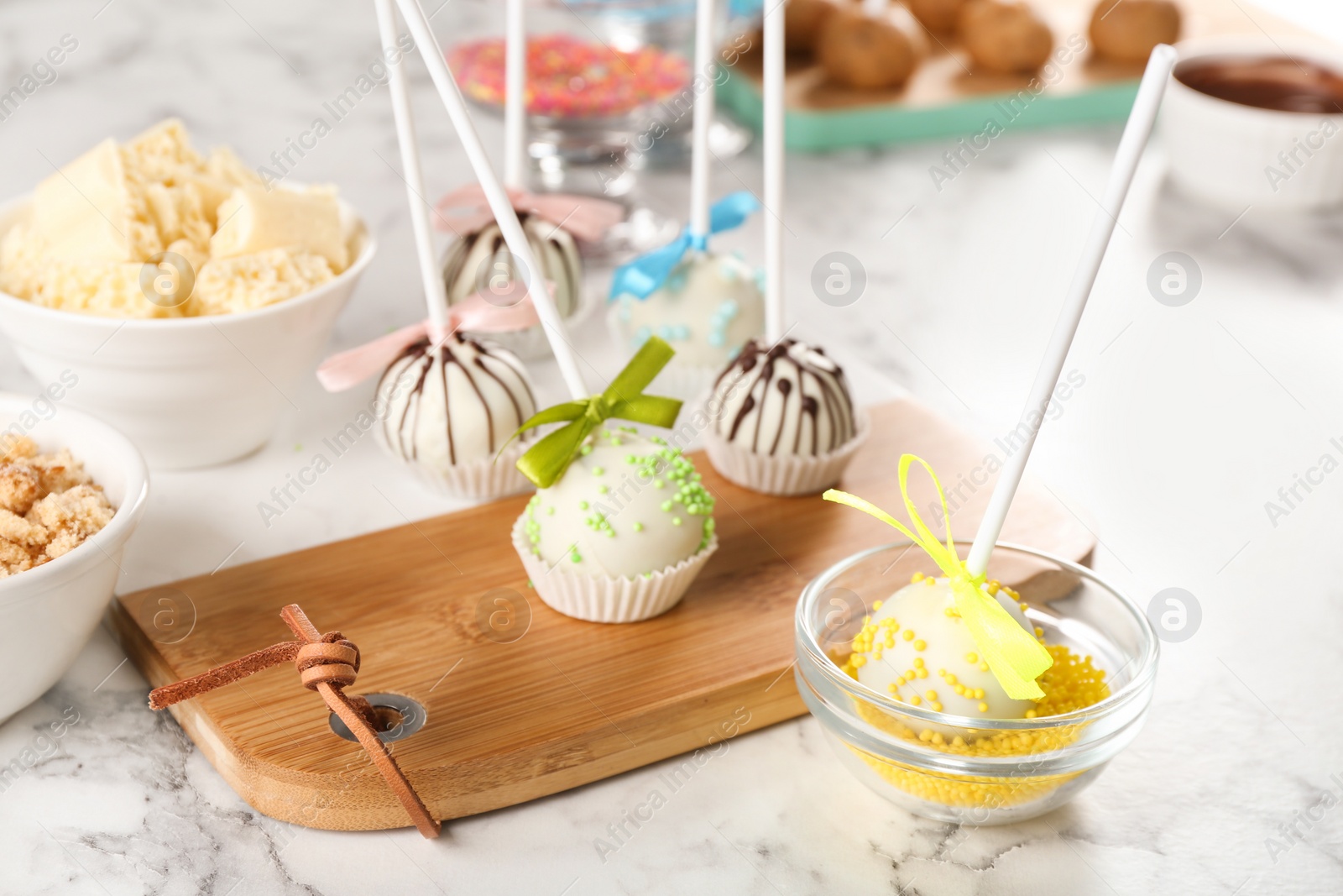 Photo of Tasty colorful cake pops on white marble table