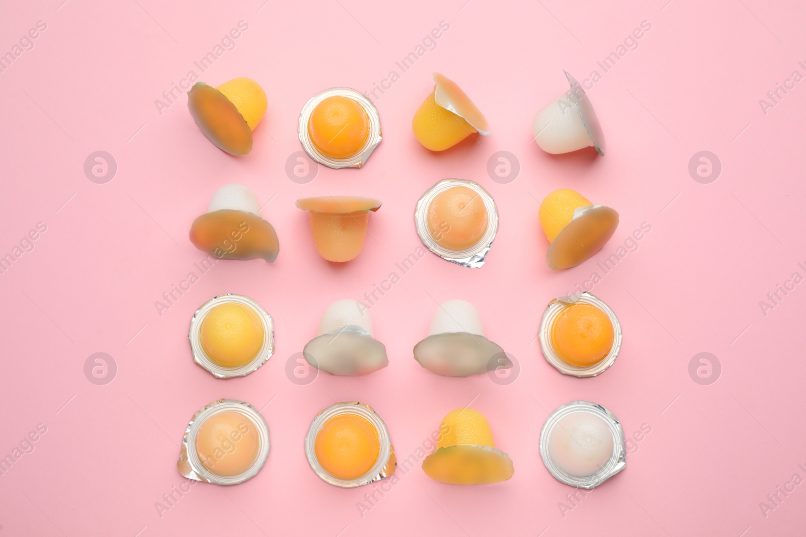 Photo of Tasty bright jelly cups on pink background, flat lay