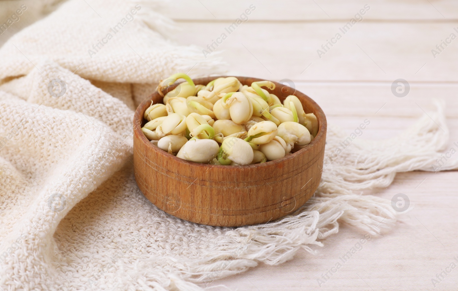 Photo of Sprouted kidney beans in bowl on white wooden table, closeup