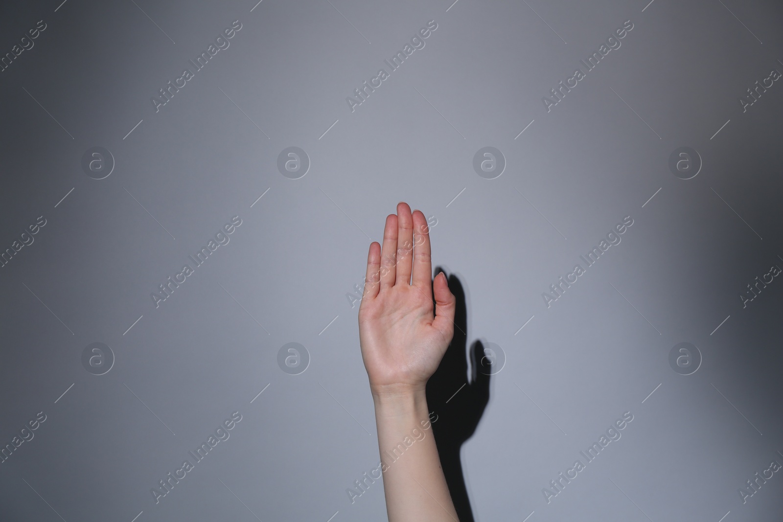 Photo of Woman showing open palm on grey background, closeup