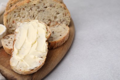 Photo of Tasty bread with butter on gray table, closeup. Space for text