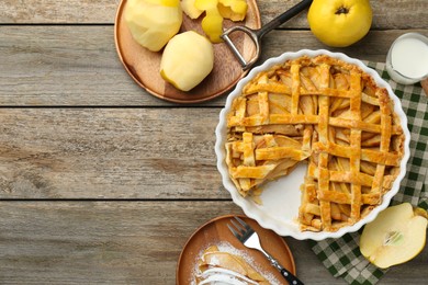 Photo of Tasty homemade quince pie, ingredients, peeler and fork on wooden table, flat lay. Space for text