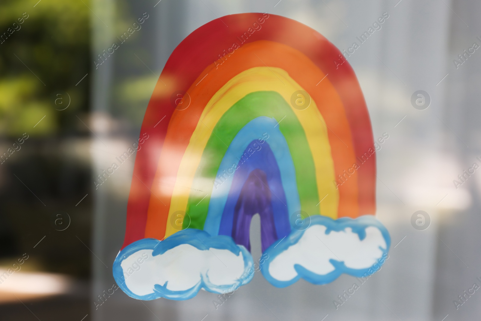 Photo of Picture of rainbow on window, view from outdoors. Stay at home concept