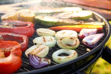 Photo of Delicious grilled vegetables on barbecue grill outdoors, closeup