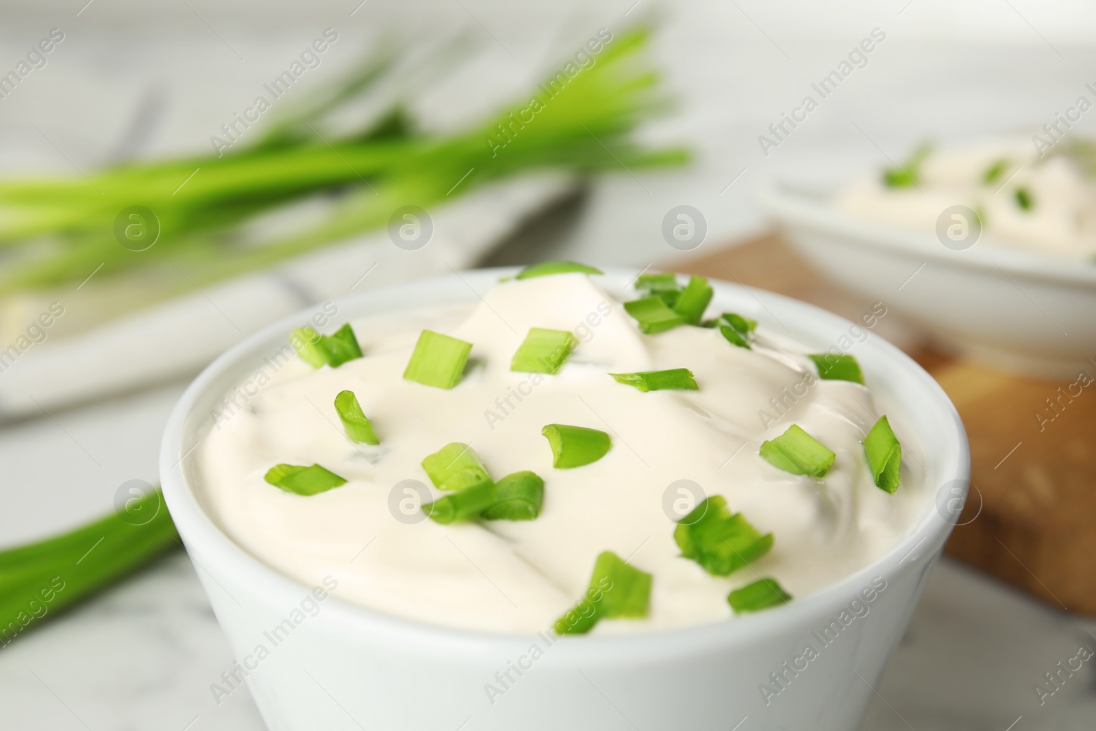 Photo of Fresh sour cream with onion in bowl, closeup