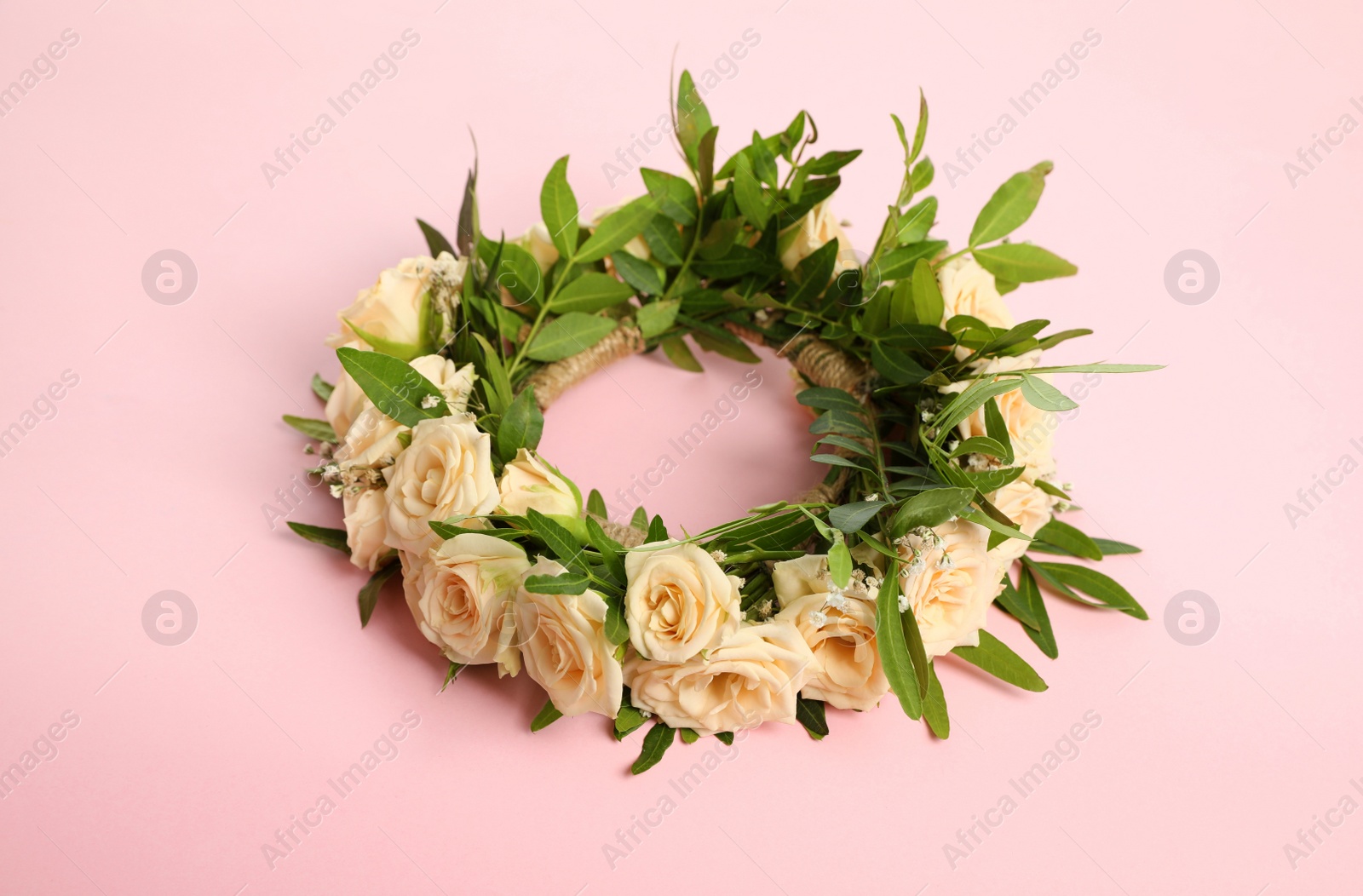 Photo of Wreath made of beautiful flowers on pink background