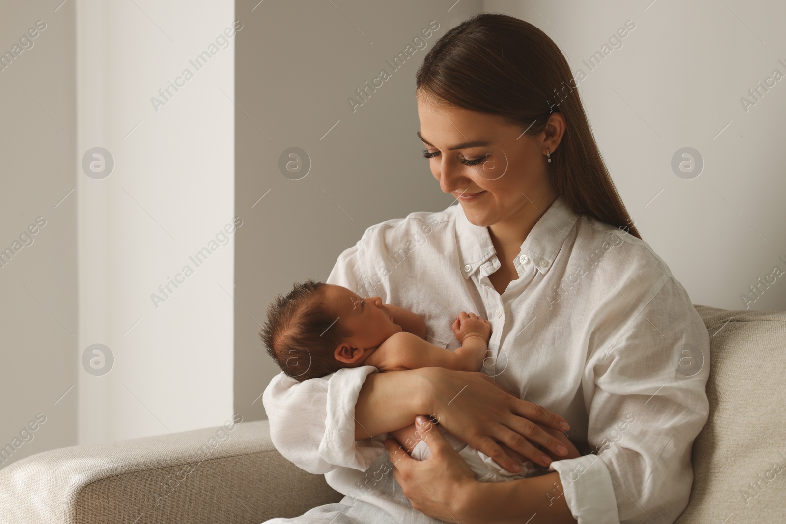 Photo of Mother holding her cute newborn baby indoors. Space for text