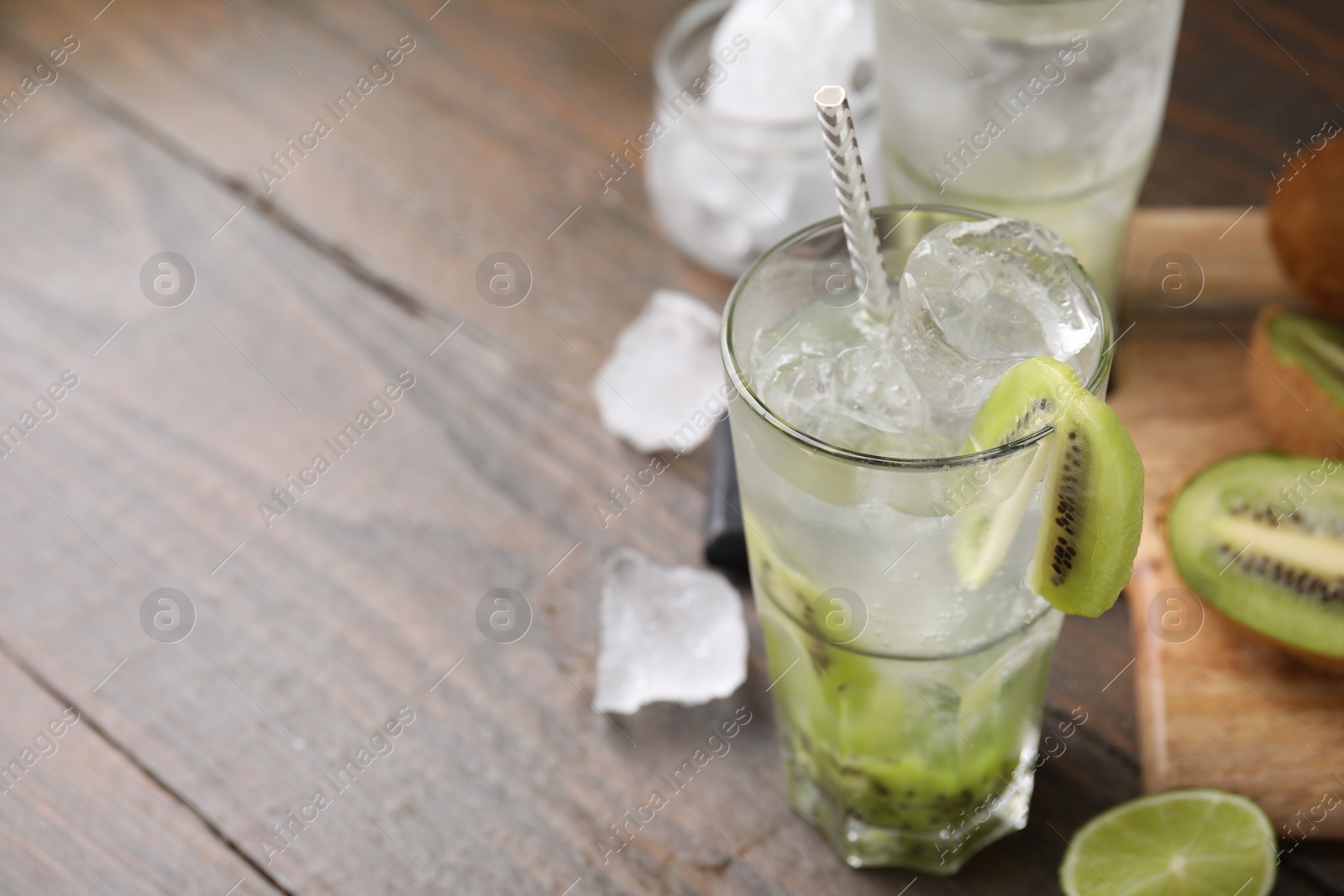 Photo of Glass of refreshing drink with kiwi on table, closeup. Space for text