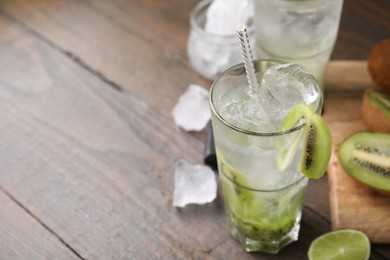 Photo of Glass of refreshing drink with kiwi on table, closeup. Space for text