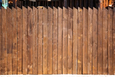 Photo of Shabby wooden fence outdoors on sunny day