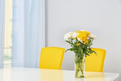 Photo of Vase with blooming flowers on table indoors