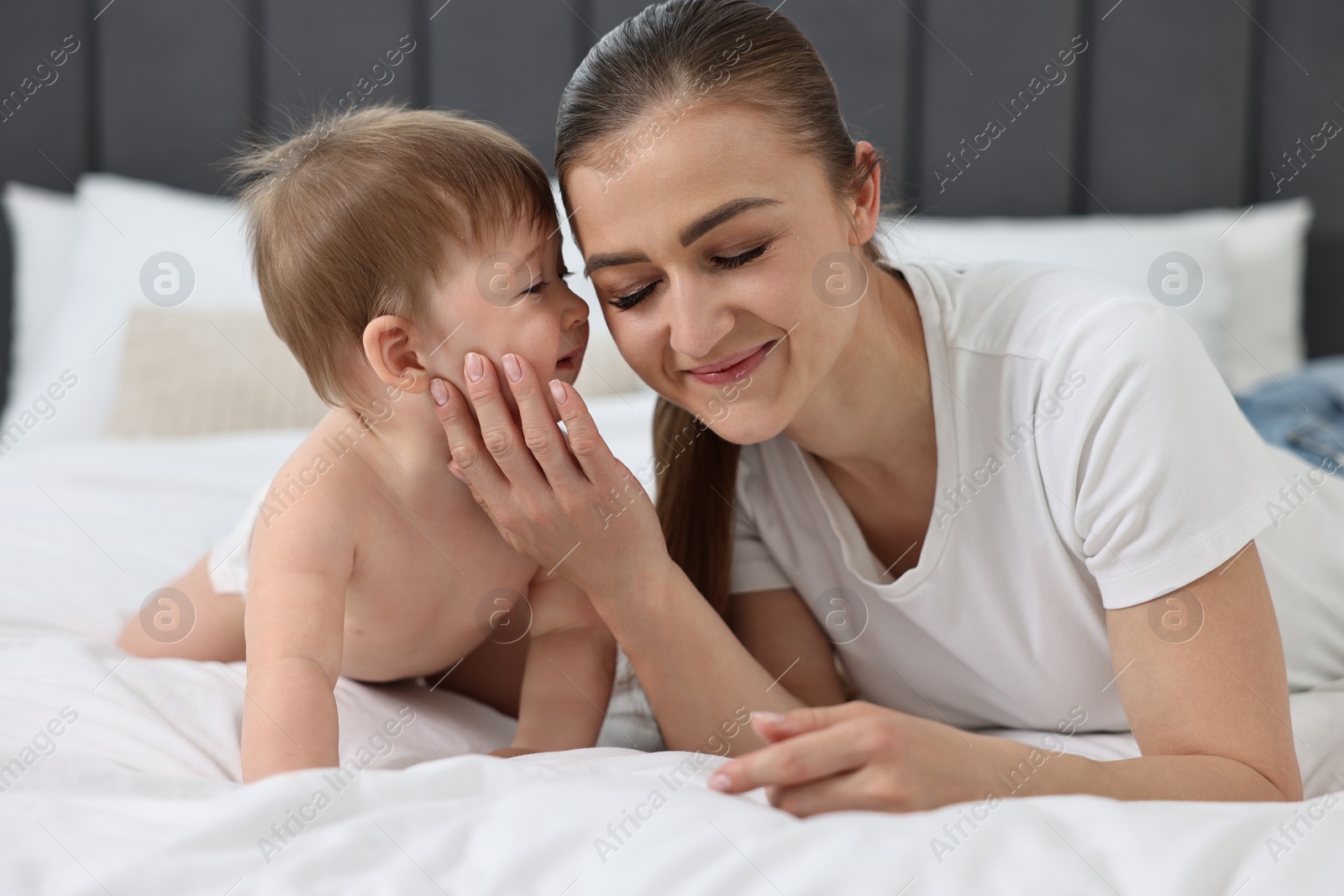 Photo of Mother with her baby on bed at home