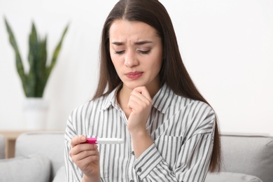 Photo of Young woman with pregnancy test at home. Gynecology and childbirth