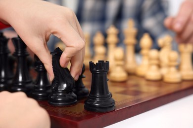 Photo of Grandfather and grandson playing chess at table, closeup