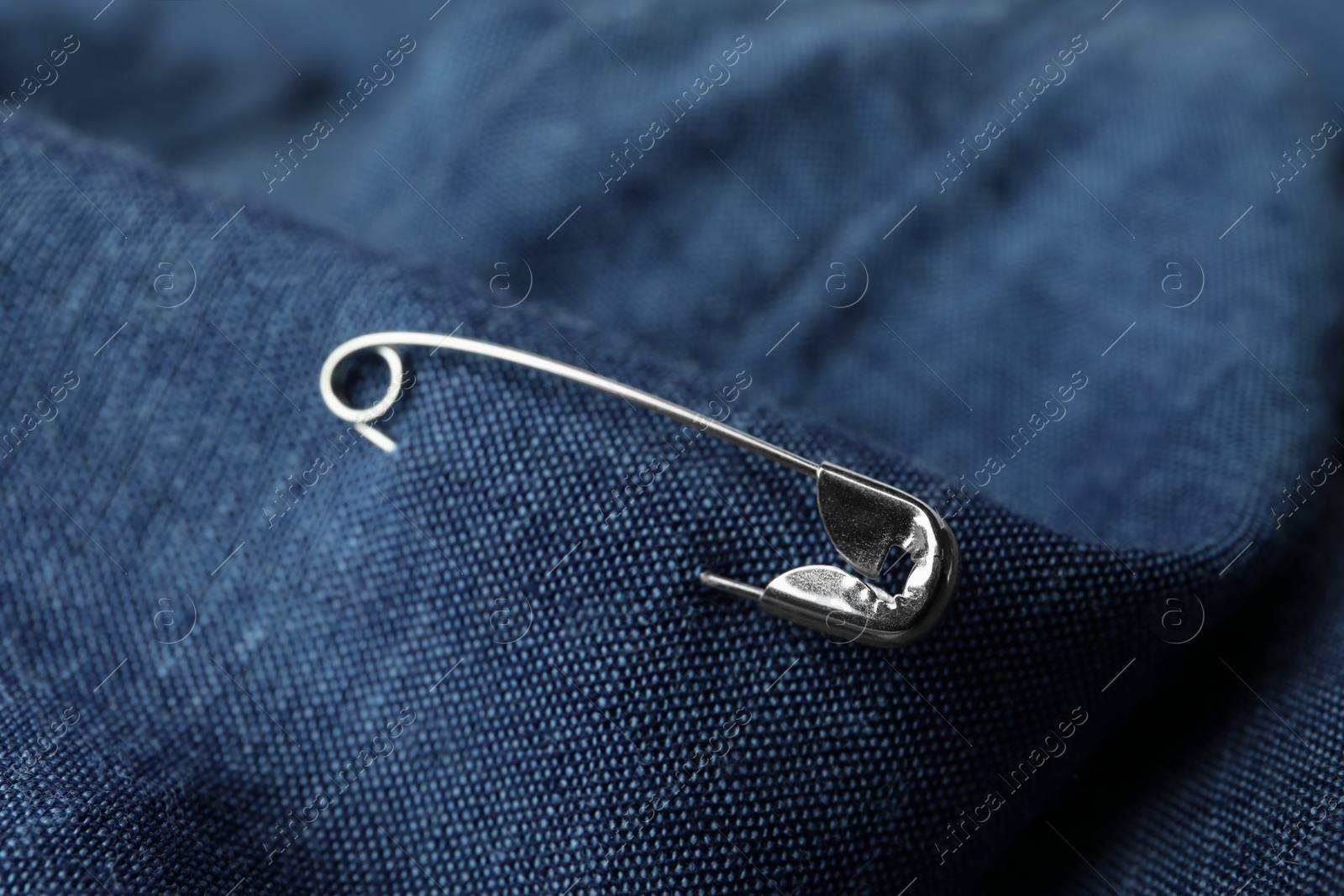 Photo of Closeup view of metal safety pin on clothing